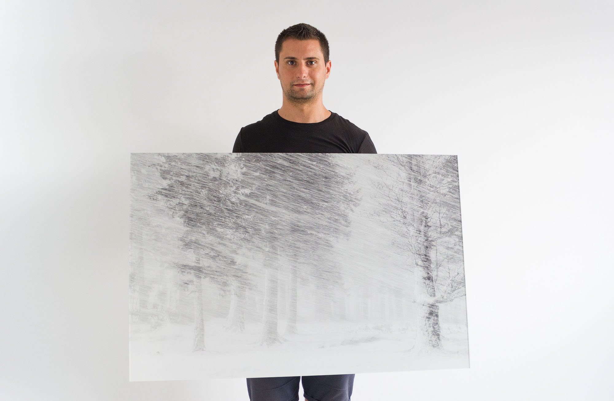 Fotograful Cosmin Stan tine in maini un tablou imens de 1 metru cu imaginea Natura deseneaza care a fost realizata in muntii Ciucas.